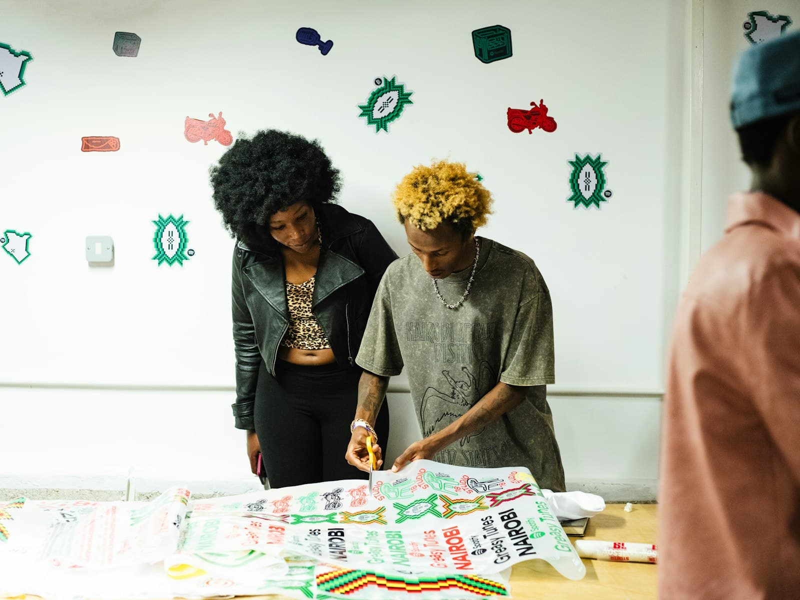 Two women lay out brightly printed fabric they designed together.
